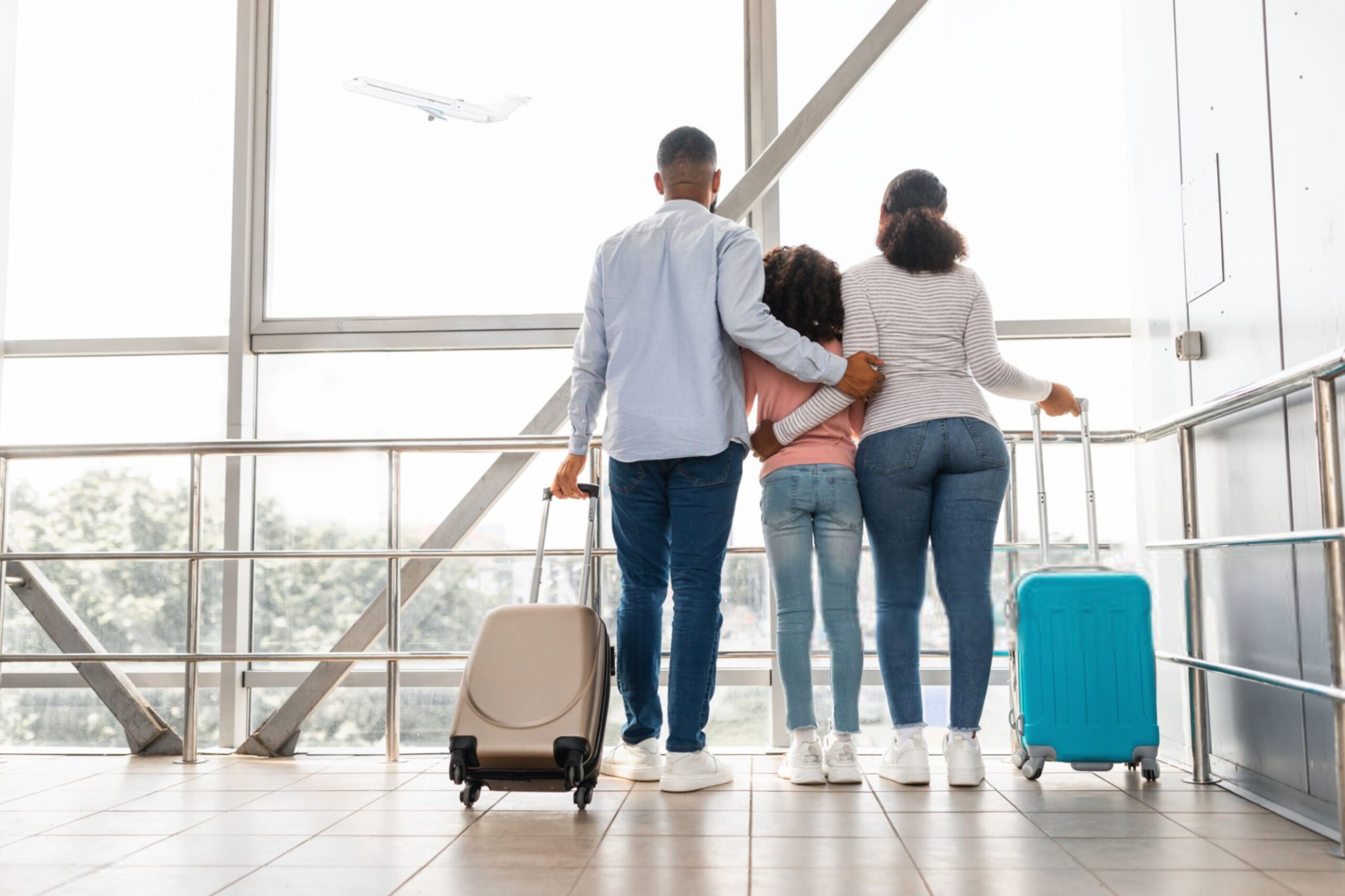 Black family traveling waiting for the aircraft arrival scaled