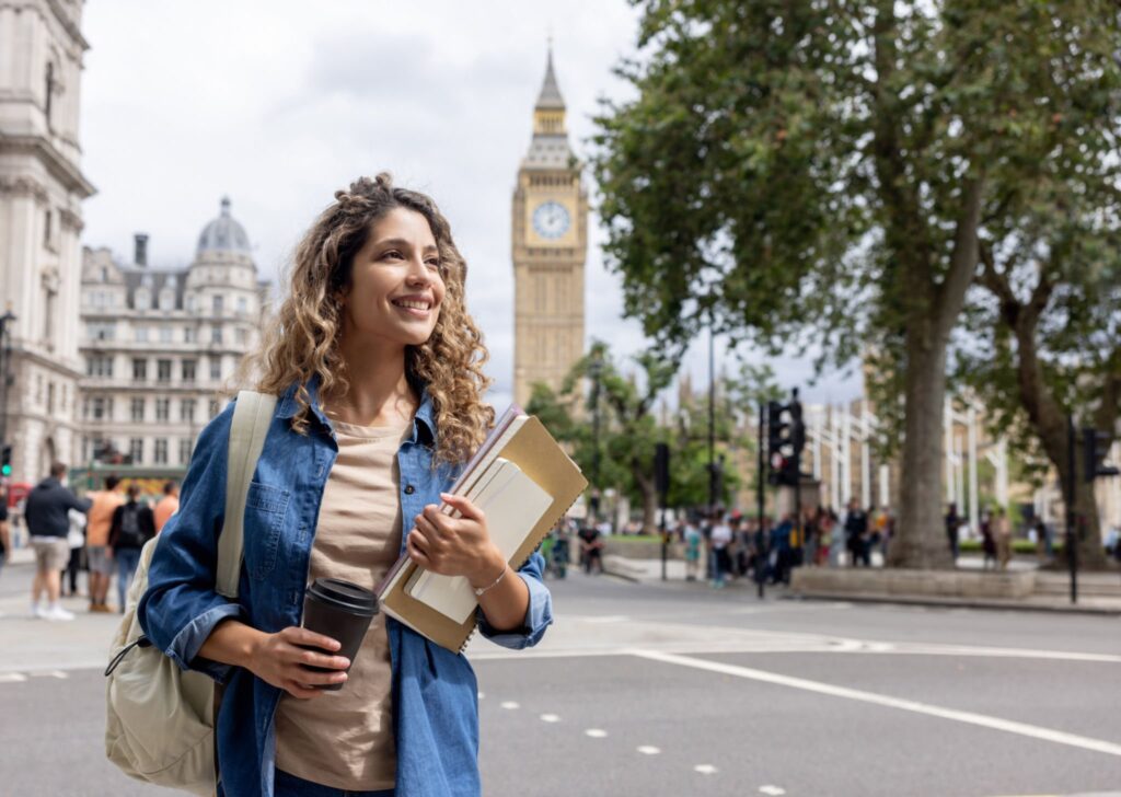 Exchange student walking outdoors in London and drinking cof 1024x728